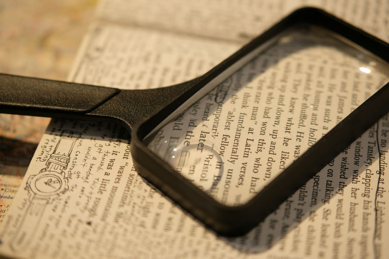A magnifying glass resting on a page of printed text